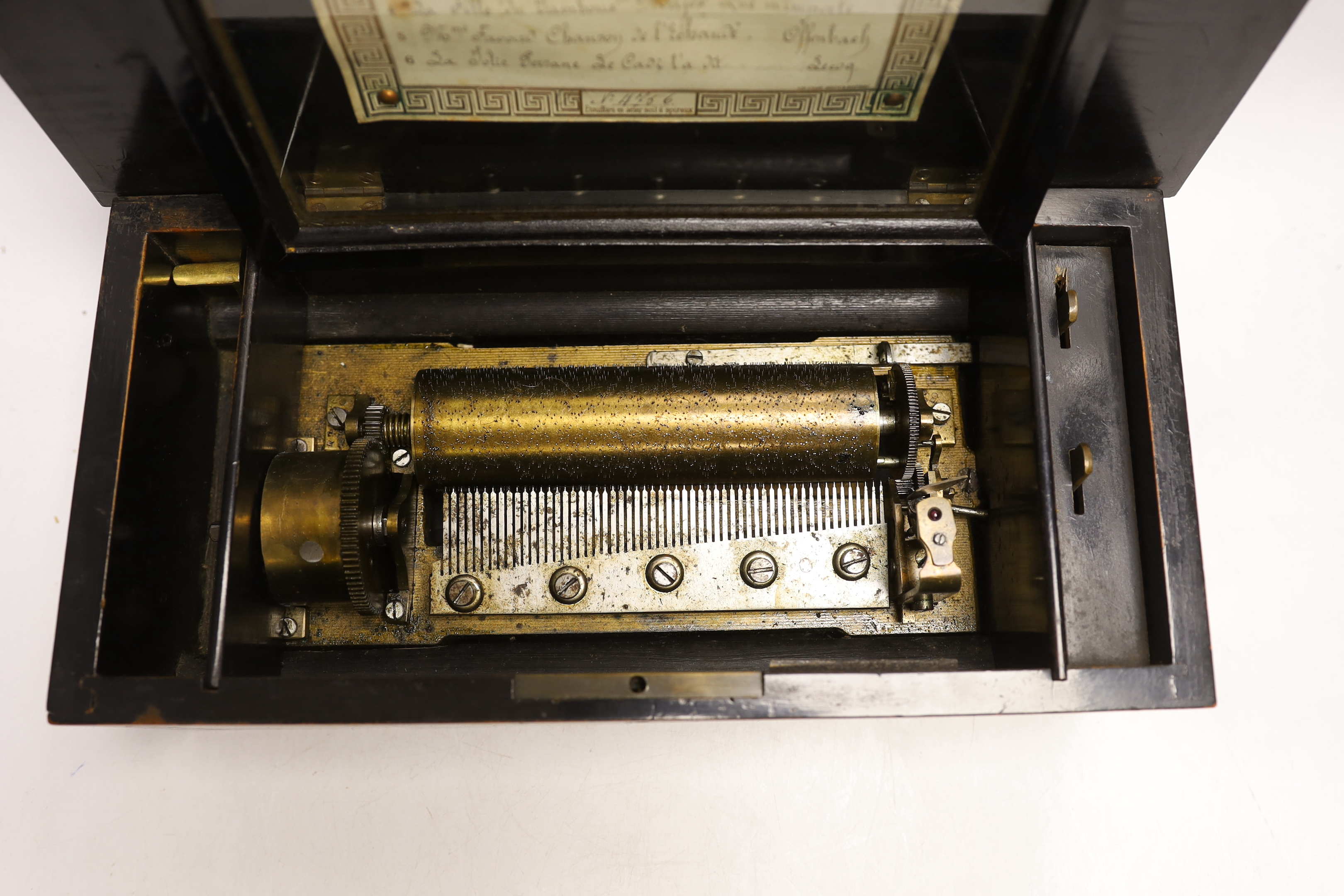 An inlaid rosewood cased musical box, single cylinder with a 56 note comb (one tooth broken and missing) playing six airs, tune list on underside of lid, 35 x 13 x 17.5cm